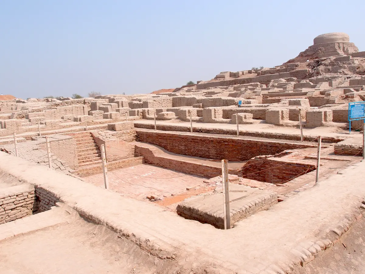 The excavated Great Bath of Mohenjo-daro with the stupa mound rising behind